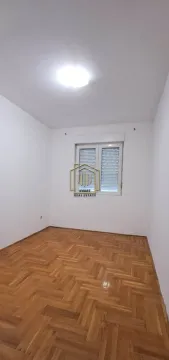 Prazna soba sa bijelim zidovima i parketom na podu. - image 9