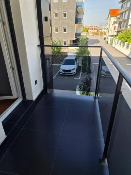 Moderna terasa sa crnim pločicama i pogledom na ulicu i parking. - image 6