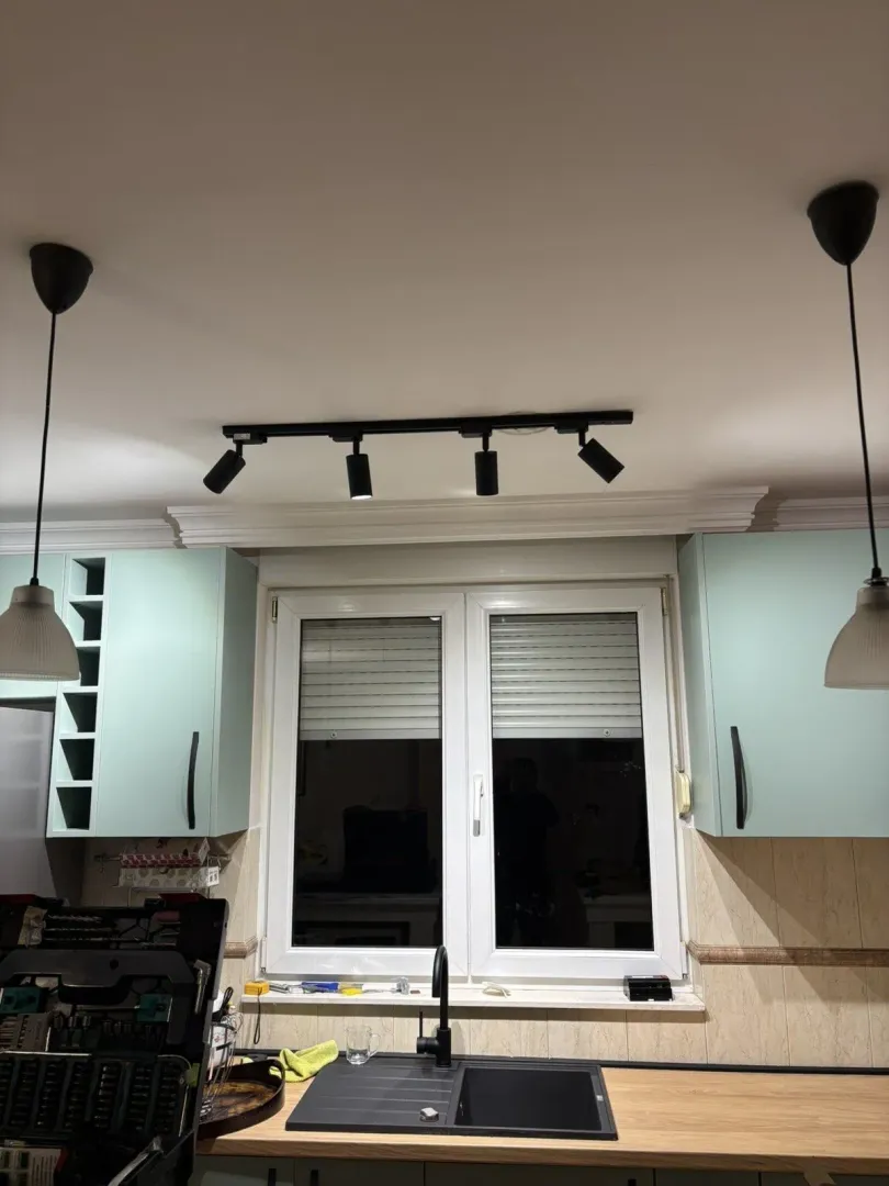Kuhinjski elementi svijetlozelene boje sa prozorom i sudoperom.