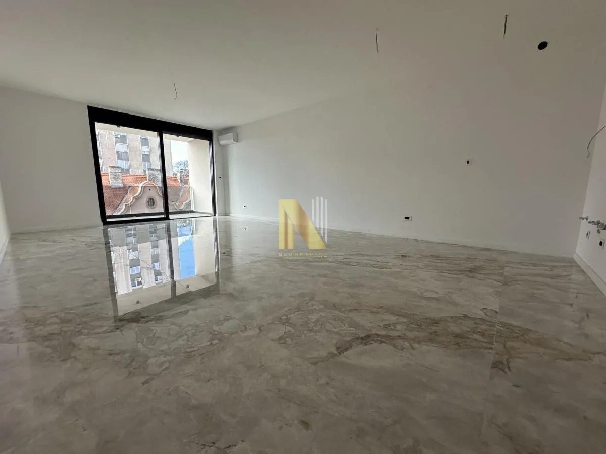Empty spacious room with glossy marble flooring and large balcony doors.
