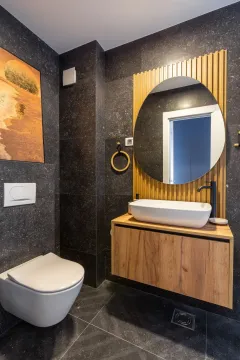 Moderno opremljeno kupatilo sa tamnim pločicama i drvenim detaljima. - image 32