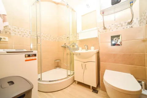 Manje kupatilo sa tuš kabinom, umivaonikom i wc šoljom obloženo keramičkim pločicama u bež tonovima. - image 8
