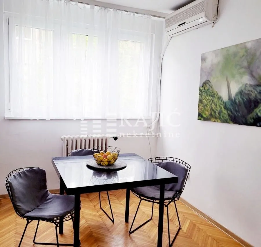 Dining area with a table, chairs, and window in a bright interior.