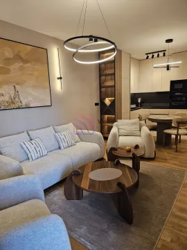 Modern open-plan living room with a sofa, dining area, and kitchen in the background. - image 22