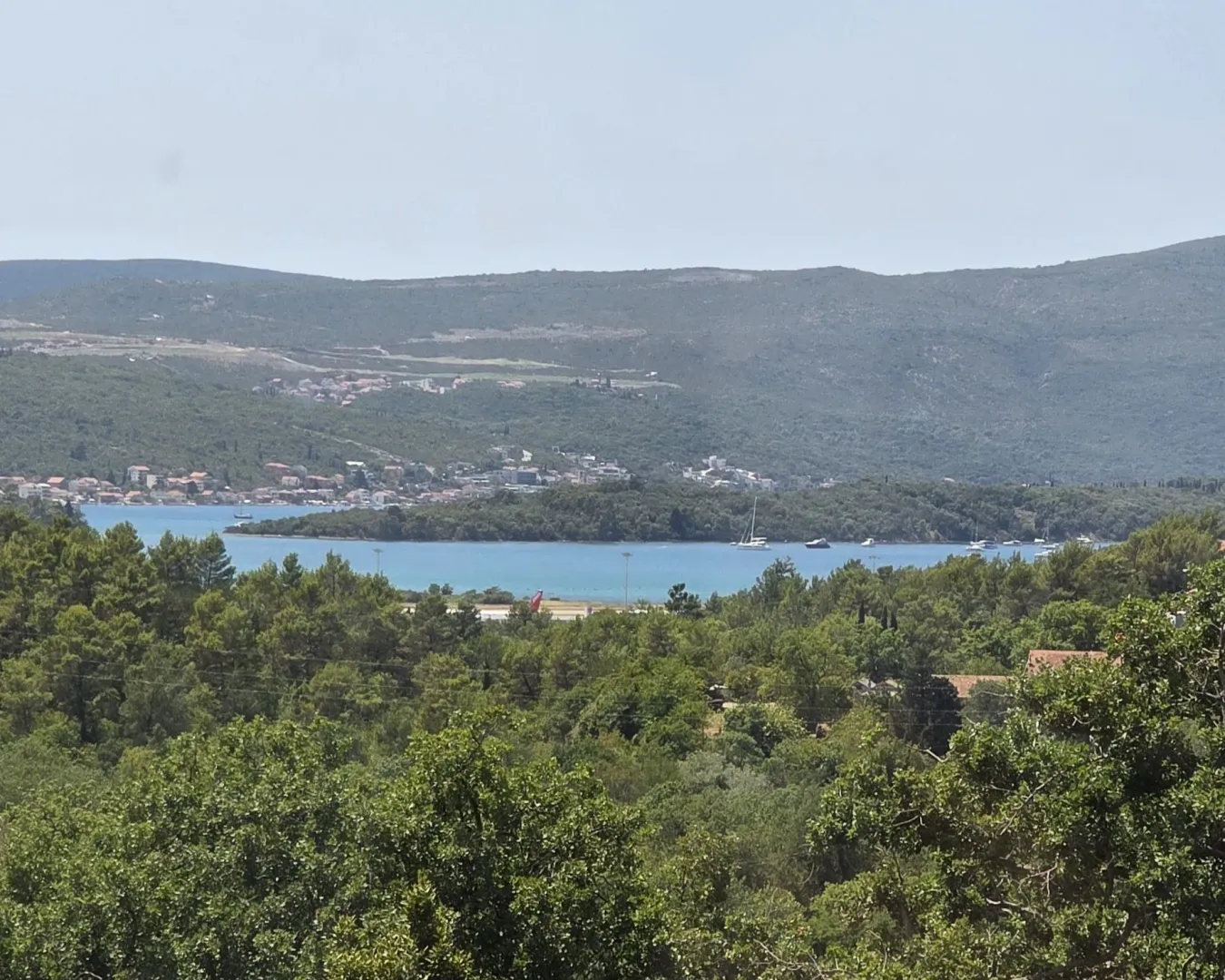 Pogled na more i okolni pejzaž sa zelenilom.
