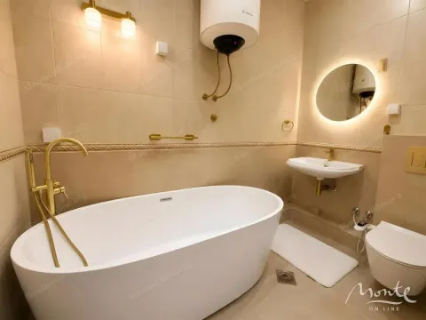 Bathroom equipped with a bathtub, washbasin, toilet, and water heater. - image 14