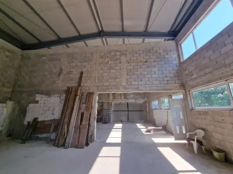 Unutrašnjost nenamještenog poslovnog prostora u sirovom stanju sa građevinskim materijalom. - image 7