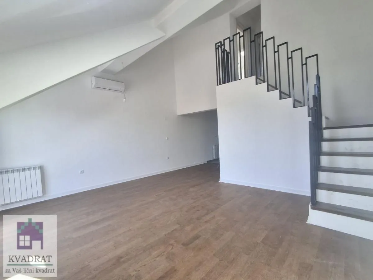 Empty living room with wooden flooring and a staircase.
