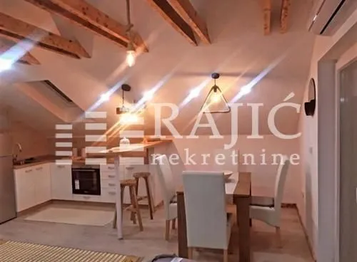 Modern kitchen with a dining area and wooden beams on the ceiling.