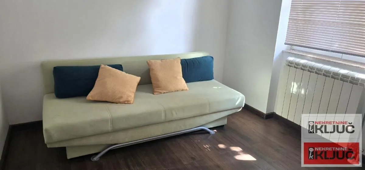 Living room with a green sofa and pillows.