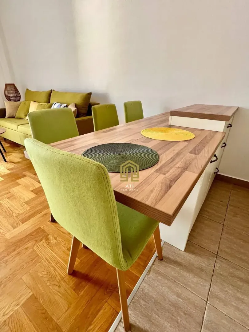 Living room with a dining table and green chairs.