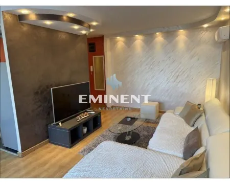 Living room with a sectional sofa, television, and drop ceiling with recessed lighting. - image 3