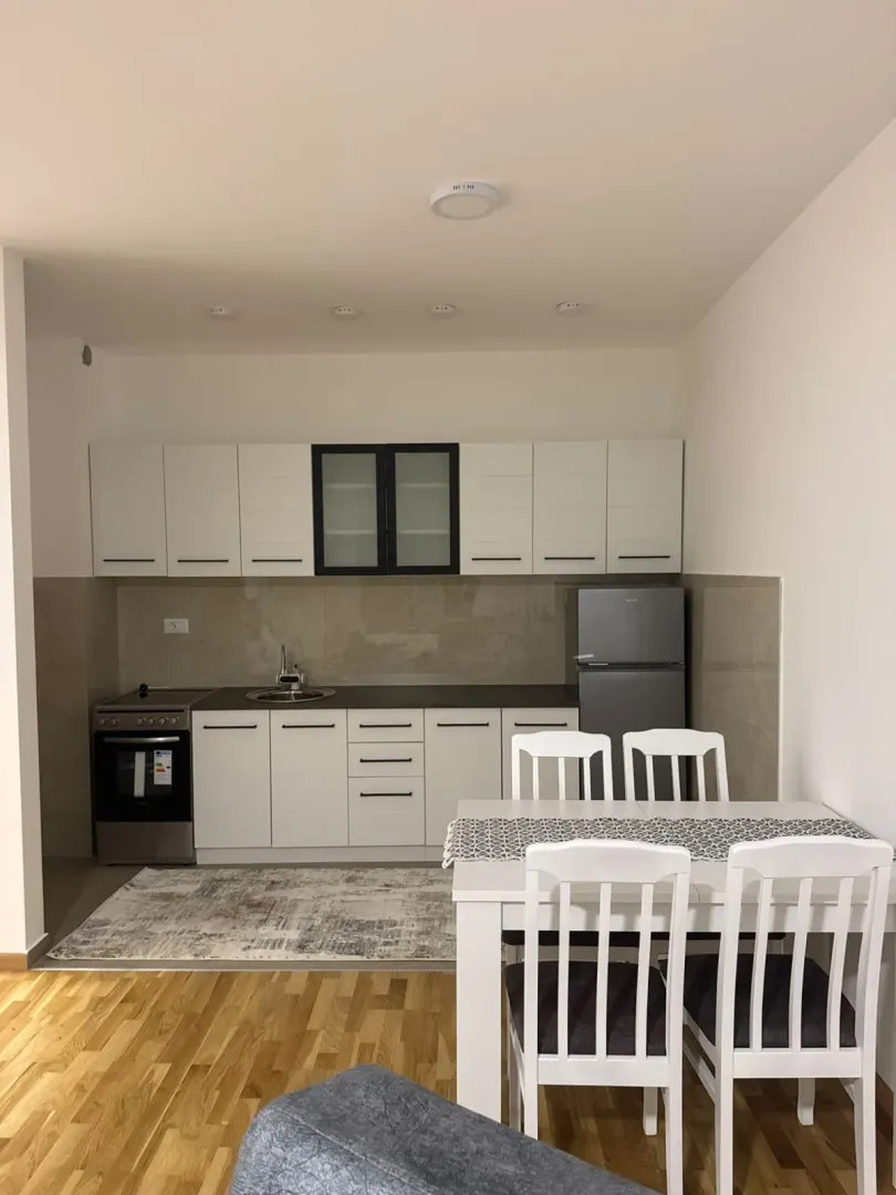 Modern kitchen with white cabinetry and a dining table.