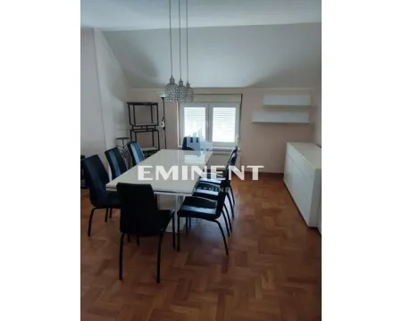 Dining area with a table, black chairs, and parquet flooring. - image 4