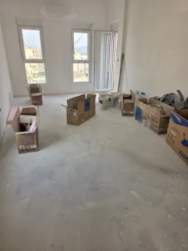 Prazna prostorija u izgradnji sa građevinskim materijalom i kutijama na podu. - image 10
