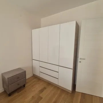 Spavaća soba sa velikim bijelim garderoberom i manjom komodom. - image 7