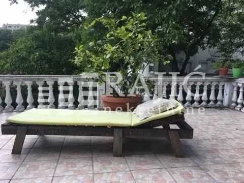 Spacious terrace with a sun lounger and decorative plants. - image 8