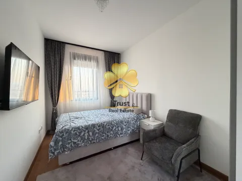 Namještena spavaća soba sa bračnim krevetom, foteljom i televizorom na zidu. - image 9