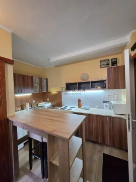 Smaller kitchen with wooden cabinets and a dining table. - image 8