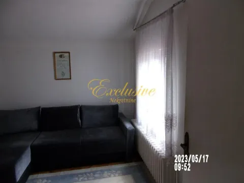 Dnevna soba sa ugaonom garniturom i prozorom sa zavesama. - image 8