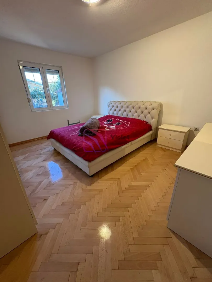 Bedroom with a double bed, bedside table, and parquet flooring.