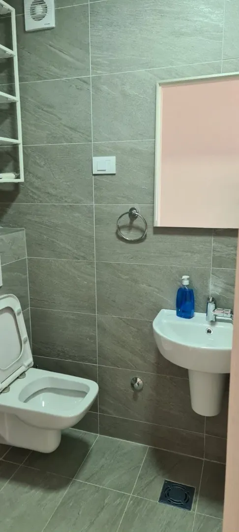 Malo kupatilo sa sivim pločicama.