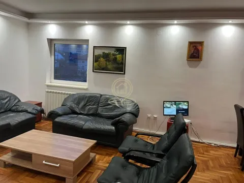 Living room with black leather furniture, a wooden coffee table, and wall paintings. - image 10