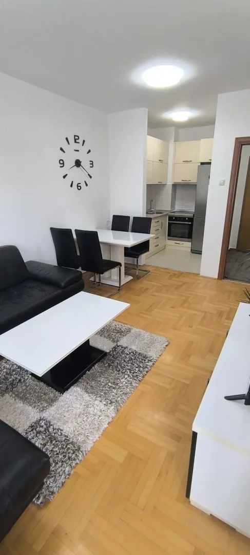 Bright living room with a dining area and kitchen in the background.