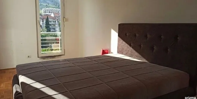 Spavaća soba sa bračnim krevetom i prozorom sa pogledom.