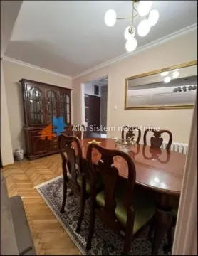 Dining room with a wooden table, chairs, and a display cabinet. - image 3