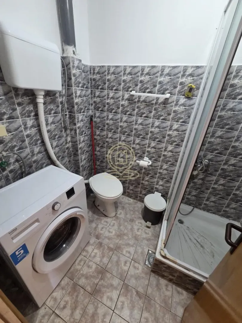 Kupatilo opremljeno tuš kabinom, WC šoljom i veš mašinom.