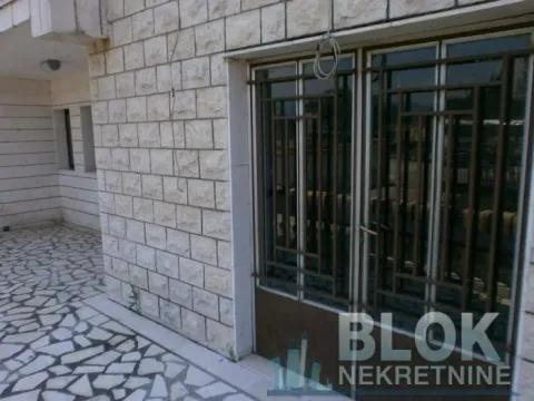 Building entrance with a paved courtyard and metal doors. - image 10