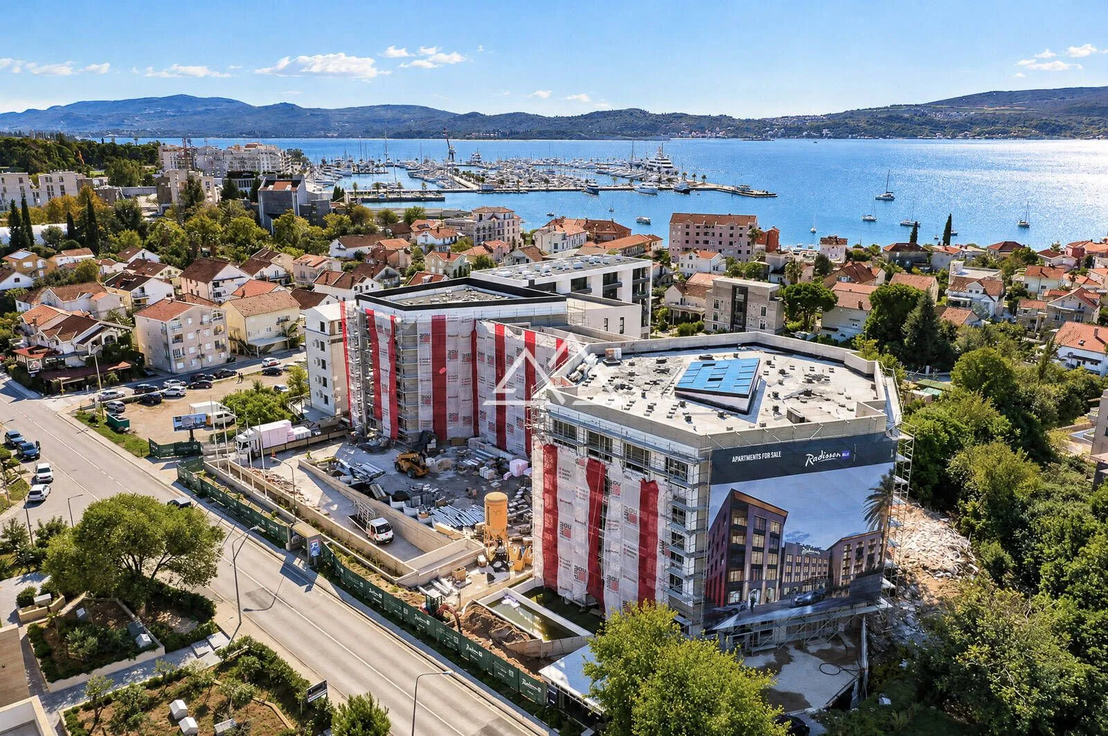 Pogled iz vazduha na stambeni objekat u izgradnji blizu obale i marine.