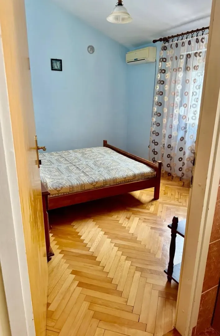 Spavaća soba sa bračnim krevetom, parketom i klima uređajem.