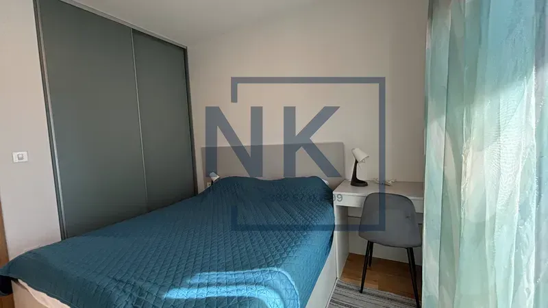 Furnished bedroom with a double bed, wardrobe, and a desk.