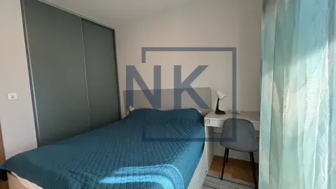 Furnished bedroom with a double bed, wardrobe, and a desk. - image 9