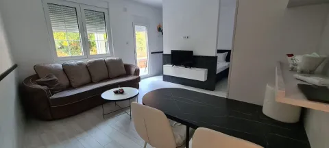 Living room with sofa, dining table, and view of the bedroom. - image 3