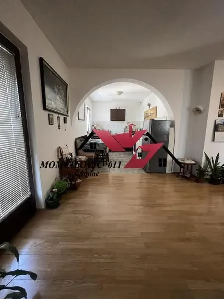 Dnevna soba sa pogledom na kuhinju kroz luk.