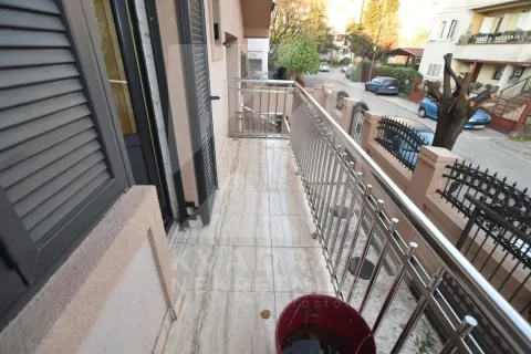 Long tiled balcony with a metal railing and street view. - image 20