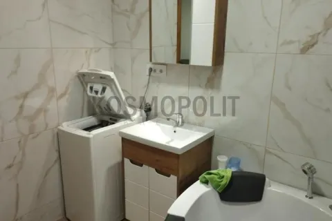 Bathroom equipped with a sink, washing machine, and bathtub, finished with ceramic tiles. - image 9