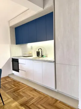 Modern kitchen with blue upper cabinets and built-in appliances. - image 5