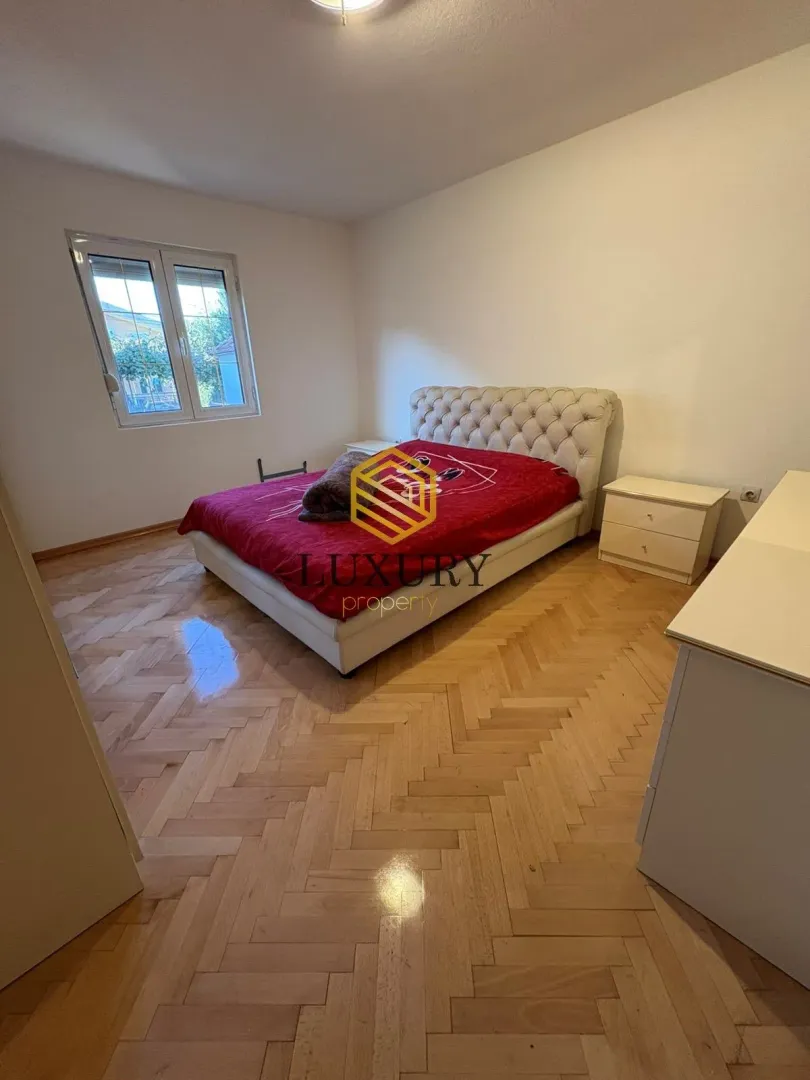 Bedroom with a double bed, nightstands, and parquet flooring.