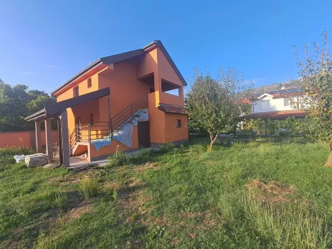 Eksterijer dvospratne kuće sa fasadom narandžaste boje i travnatim dvorištem. - image 2