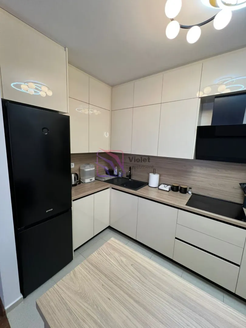 Modern kitchen with built-in cabinetry and a black refrigerator.