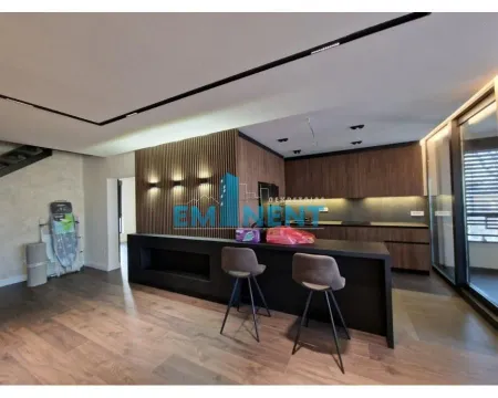 Modern kitchen with a bar counter, wooden wall panels, and built-in units. - image 9