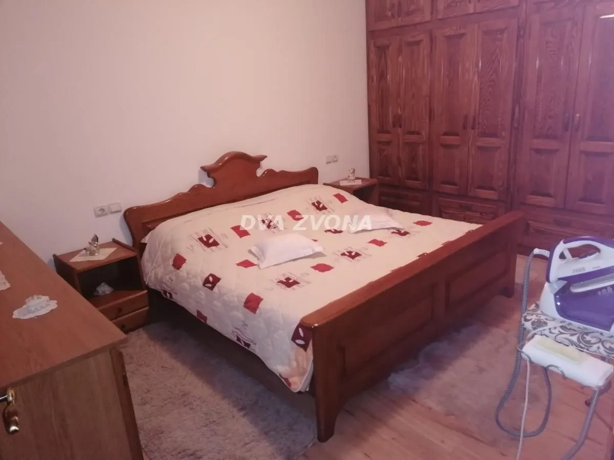 Bedroom with a double bed, wooden wardrobe and nightstands.