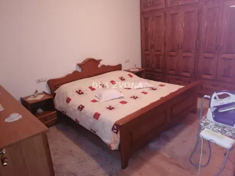 Bedroom with a double bed, wooden wardrobe and nightstands. - image 24
