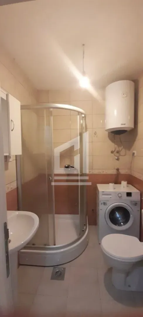 Kupatilo sa tuš kabinom, umivaonikom, WC šoljom, veš mašinom i bojlerom.