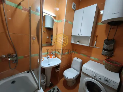 Manje kupatilo sa narandžastim pločicama, tuš kabinom, umivaonikom i veš mašinom. - image 17
