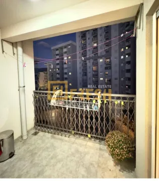 Natkriveni balkon sa metalnom ogradom i pogledom na okolne zgrade. - image 2